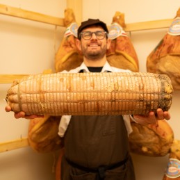 Pancetta Piacentina stagionatura riserva intera in mano in cantina