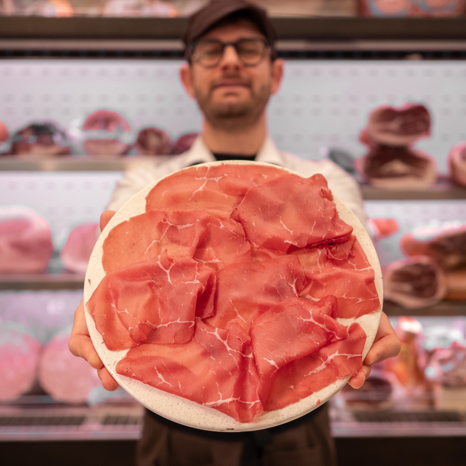 fette di Bresaola punta d'anca artigianale su tagliere in mano