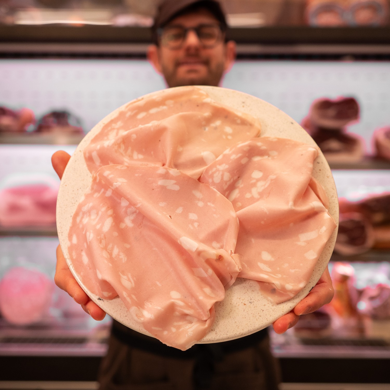 tagliere di mortadella affettata in mano