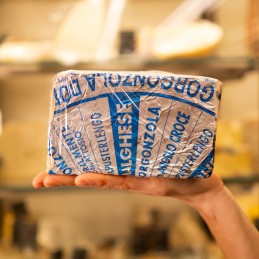 fetta di gorgonzola piccante in mano